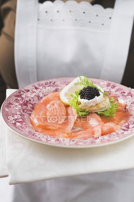 Копченый лосось с икрой на тарелке — стоковое фото