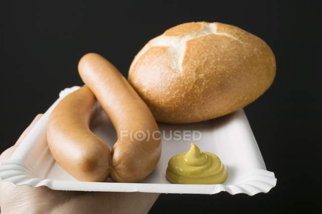 Сосиски с горчицей и рулон хлеба — стоковое фото