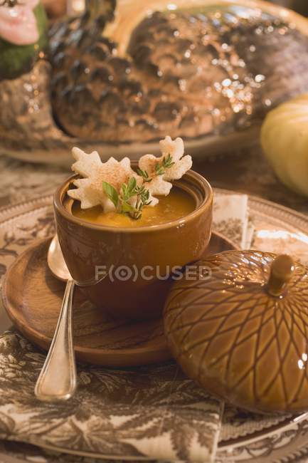 Closeup view of pumpkin soup with cookie and herb — Stock Photo