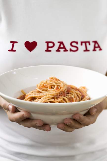 Woman holding pasta plate of spaghetti — Stock Photo