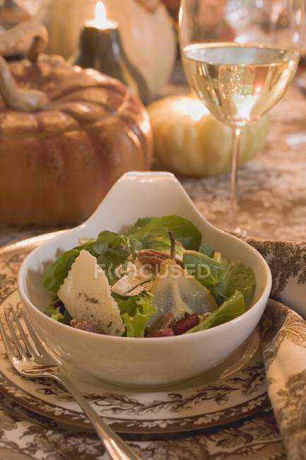 Крупный план салата и бокала вина на накрытом столе — стоковое фото
