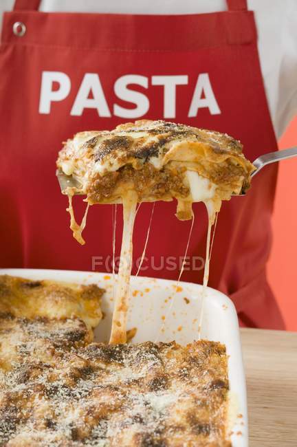 Woman taking portion of lasagne — Stock Photo