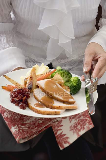 Cropped view of woman serving turkey breast with vegetables — Stock Photo