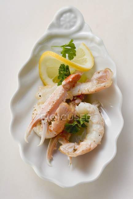 Closeup top view of scampi with lemon and parsley — Stock Photo
