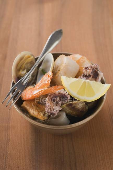 Primo piano vista di frutti di mare con spicchio di limone e forchetta in ciotola — Foto stock