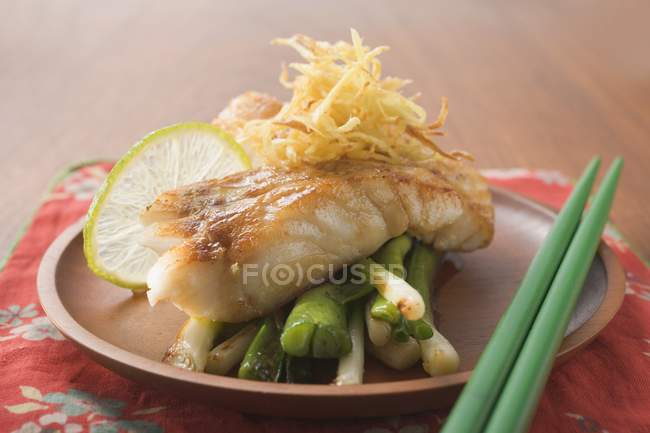 Fish fillet with spring onions and lime — Stock Photo