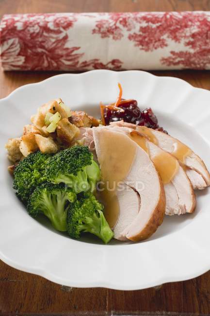 Turkey breast with broccoli, bread stuffing and cranberries  on white plate — Stock Photo