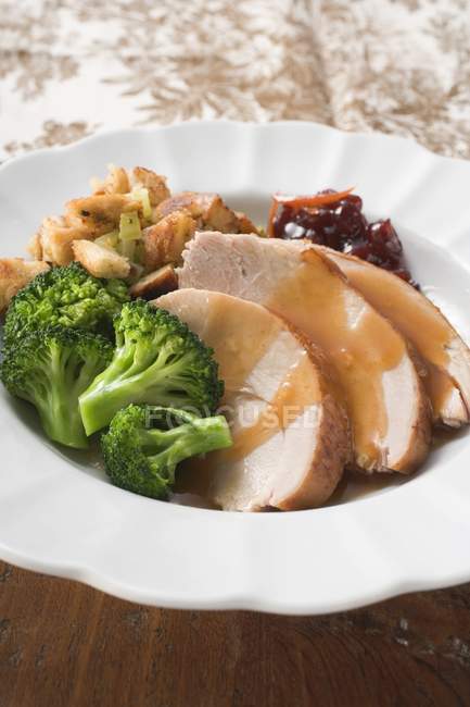 Turkey breast with broccoli, bread stuffing and cranberries on white plate — Stock Photo
