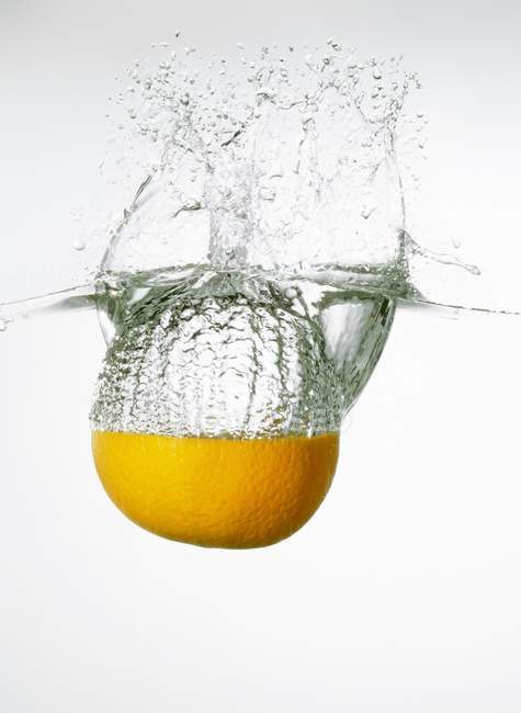 Orange fällt ins Wasser — Stockfoto