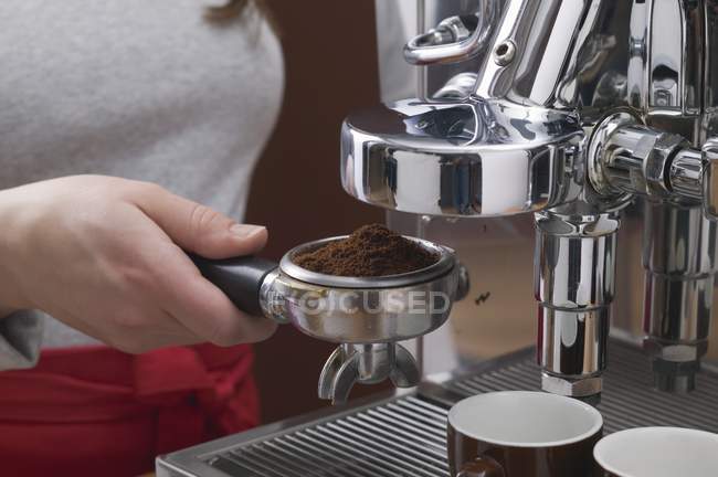 Cropped view of woman holding filter holder of Espresso machine with coffee powder — Stock Photo