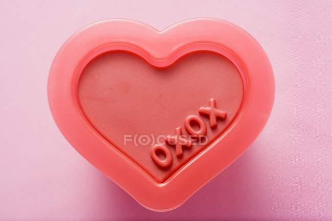 Vista superior closeup do molde plástico em forma de coração com a marcação oxox — Fotografia de Stock