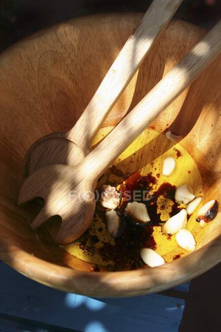 Wooden salad bowl and salad servers with dressing — Stock Photo