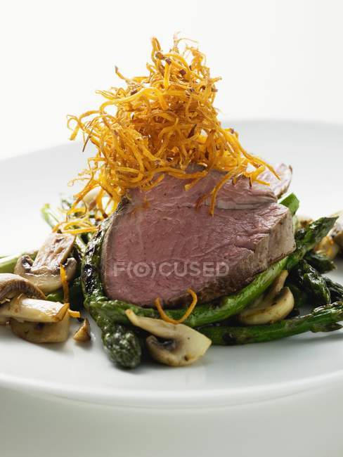 Roasted Beef fillet on green asparagus — Stock Photo