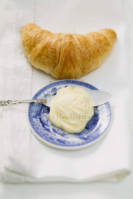 Croissant au beurre et couteau — Photo de stock
