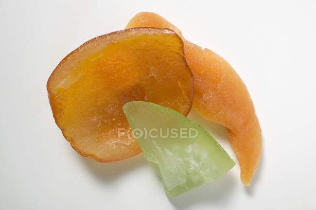Closeup view of candied fruit pieces on white surface — Stock Photo