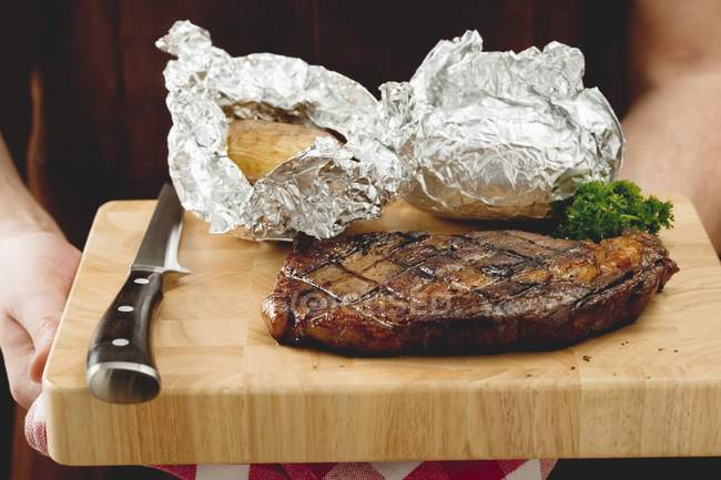 Grilled steak with baked potatoes — Stock Photo