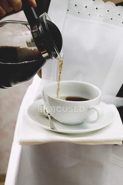 Mãos femininas derramando café — Fotografia de Stock