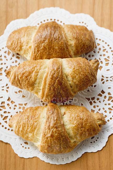 Croissants auf weißer Spitzenserviette — Stockfoto