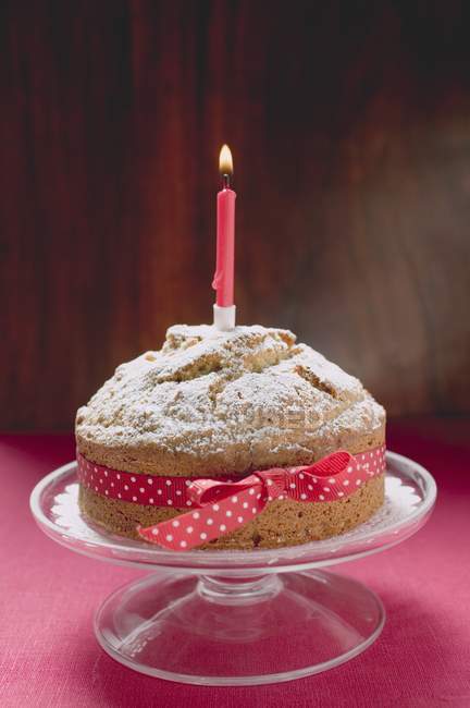 Birthday cake with red bow — Stock Photo