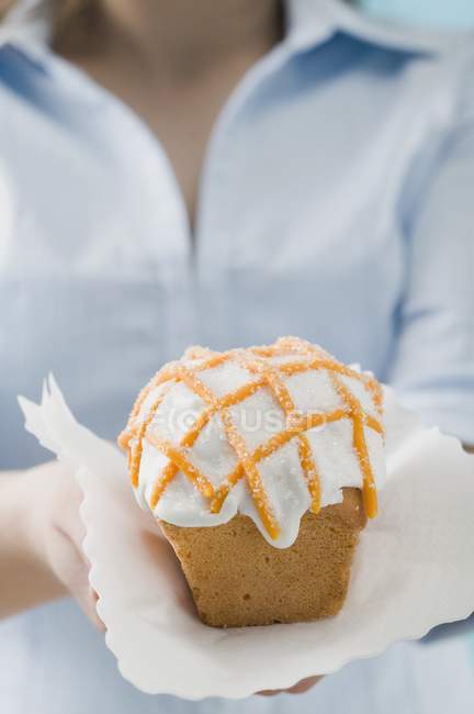 Femme tenant gâteau orange glacé — Photo de stock