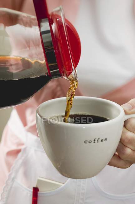 Frauenhände gießen Kaffee ein — Stockfoto