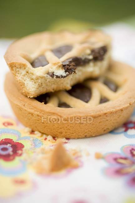Chocolate tartlets on tablecloth — Stock Photo