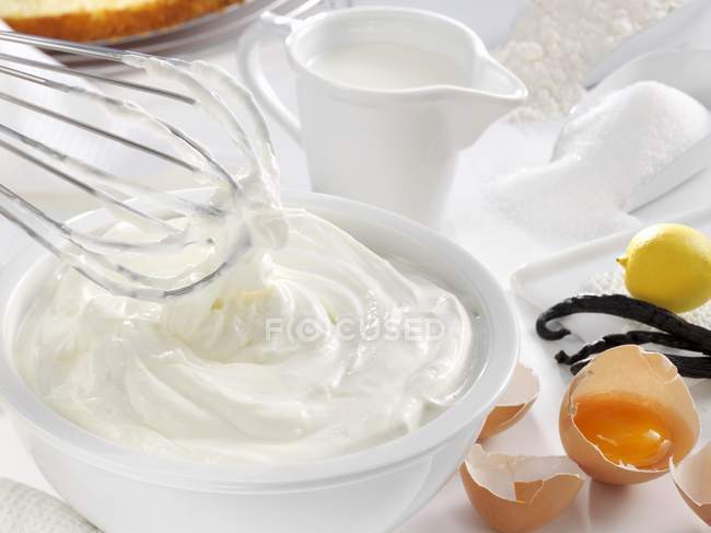 Vista de primer plano de la crema batida y varios ingredientes para hornear - foto de stock