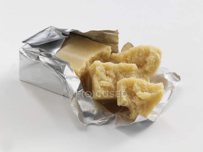 Closeup view of marzipan pieces in opened foil packaging — Stock Photo