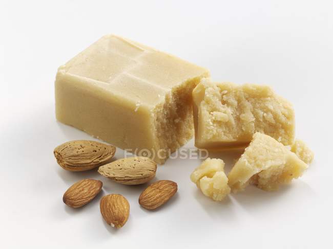 Closeup view of marzipan and almonds on white surface — Stock Photo