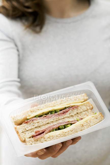 Женщина с двумя бутербродами — стоковое фото