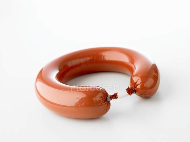 Closeup view of ring bologna sausage on white surface — Stock Photo