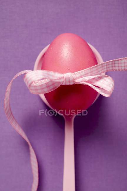 Top view of red Easter egg with bow on spoon — Stock Photo