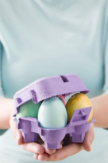 Mulher segurando ovos de páscoa coloridos — Fotografia de Stock