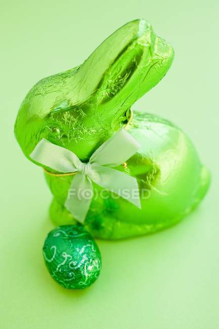 Green Easter Bunny and chocolate egg — Stock Photo