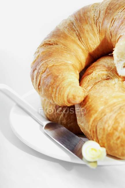 Croissants na placa com faca — Fotografia de Stock