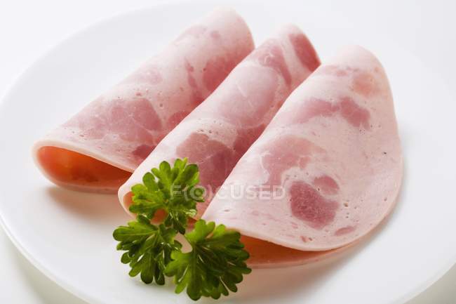 Slices of Bierschinken ham sausage with parsley — Stock Photo