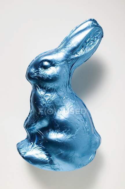 Coelho de chocolate em folha azul — Fotografia de Stock