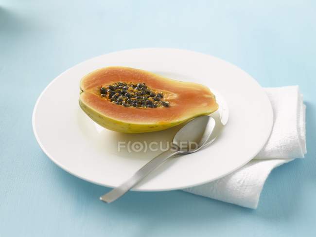 Половина свіжої папайї в тарілці — стокове фото