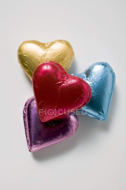 Chocolate hearts in coloured foil — Stock Photo