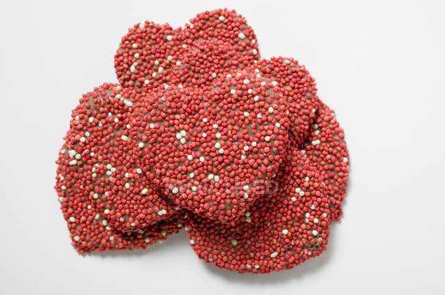 Corações de chocolate empilhados com polvilhas — Fotografia de Stock