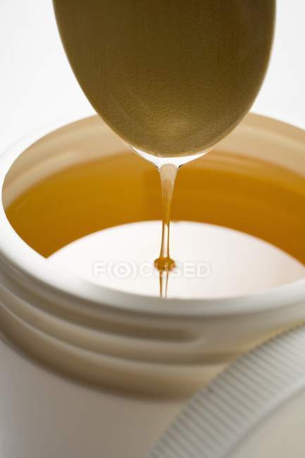 Honey running from spoon — Stock Photo