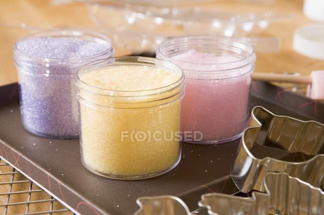 Vista de primer plano de azúcar de color en frascos en bandeja - foto de stock