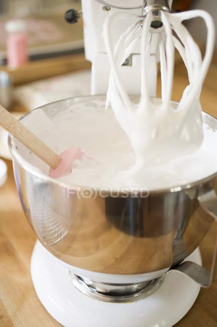 Vista de primer plano de la crema batida en el tazón de mezcla de un mezclador de alimentos - foto de stock