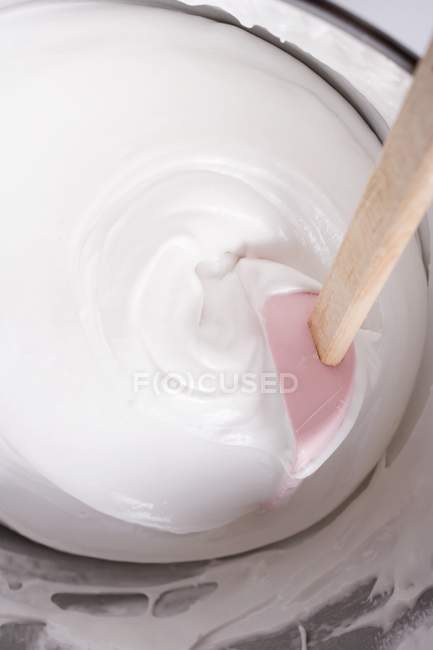 Vue rapprochée du dessus de la crème de mélange dans un bol avec spatule — Photo de stock