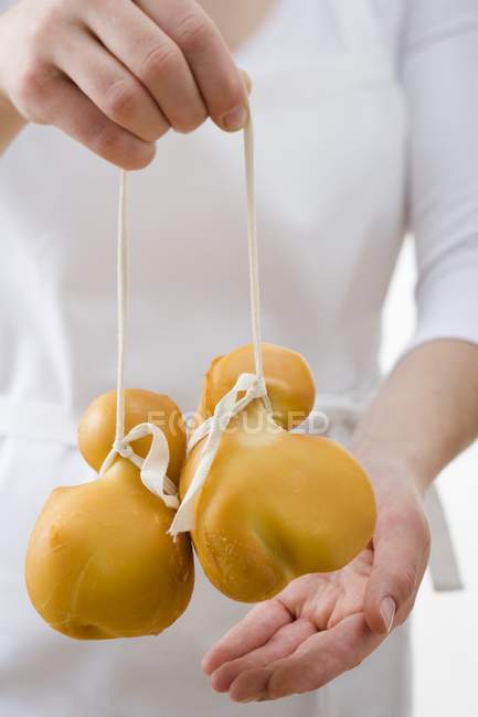 Woman holding two Provolone cheeses — Stock Photo