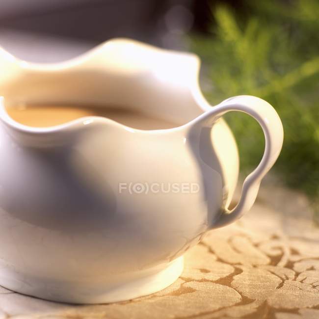 Closeup view of white sauce in sauce-boat — Stock Photo