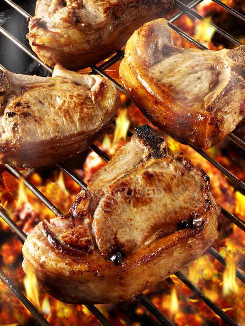 Pork chops on barbecue rack — Stock Photo