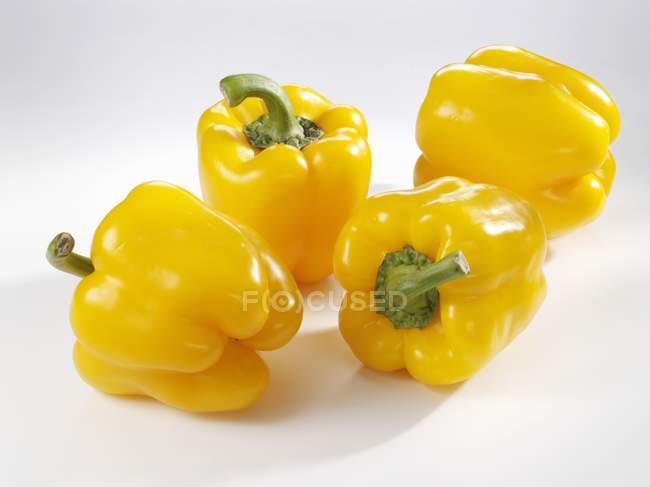 Four yellow peppers — Stock Photo