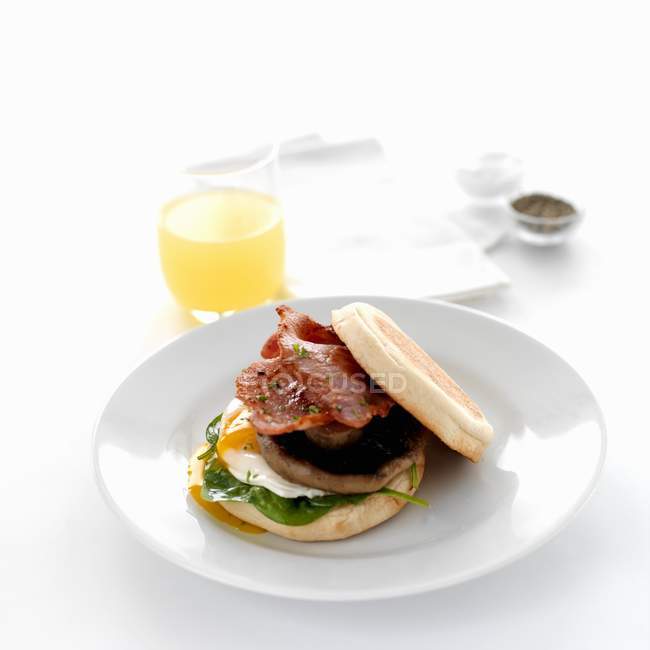 Elevated view of egg, ham and mushroom burger and juice — Stock Photo