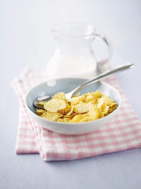 Vista de primer plano de los copos de maíz con leche para el desayuno - foto de stock